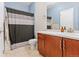 Well-lit bathroom featuring a wood vanity and tub shower with striped curtain at 2682 S Cathay Way # 307, Aurora, CO 80013