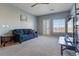 Bright living room features a comfortable blue sofa, ceiling fan and access to the outdoors at 2682 S Cathay Way # 307, Aurora, CO 80013