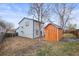 View of the backyard, showcasing a shed, wood fence, bare lawn and the home's exterior at 16325 E Alabama Dr, Aurora, CO 80017