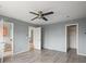 Spacious bedroom with neutral tones featuring a ceiling fan and an adjacent bathroom at 16325 E Alabama Dr, Aurora, CO 80017