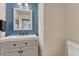 Modern bathroom with a vanity, blue accent wall, and a toilet at 3367 Dove Valley Pl, Castle Rock, CO 80108
