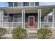 Inviting front porch with white pillars, brick accents, and a vibrant red door with decorative wreath at 3367 Dove Valley Pl, Castle Rock, CO 80108