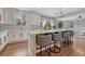 Stylish kitchen with a large island with seating, white cabinetry, and views into an adjacent living area at 3367 Dove Valley Pl, Castle Rock, CO 80108