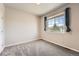 Neutral bedroom with window, plush carpeting, and natural light, offering a cozy and inviting space at 6612 S Muscadine Ct, Aurora, CO 80016