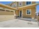 Tan two-story home featuring a two-car garage and welcoming covered porch at 6612 S Muscadine Ct, Aurora, CO 80016