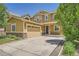 Tan two-story home featuring a two-car garage and charming stone accents at 6612 S Muscadine Ct, Aurora, CO 80016