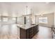 Modern kitchen with granite counters and stainless steel appliances open to large living area at 6612 S Muscadine Ct, Aurora, CO 80016