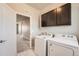 Functional laundry room with washer, dryer, and overhead cabinets, providing convenient storage and organization at 6612 S Muscadine Ct, Aurora, CO 80016