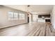 Open-concept living room boasts wood floors, large windows and flows into the kitchen, creating an inviting space at 6612 S Muscadine Ct, Aurora, CO 80016