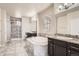 Bright main bathroom featuring dual vanities, a glass-enclosed shower, and a soaking tub for relaxation at 6612 S Muscadine Ct, Aurora, CO 80016