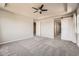 Spacious main bedroom with ceiling fan, tray ceilings, carpet, and a stylish sliding barn door entry to bath at 6612 S Muscadine Ct, Aurora, CO 80016