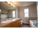 Double sink bathroom with soaking tub and tile flooring at 11477 Iola St, Commerce City, CO 80640