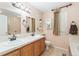 Spacious bathroom featuring a double sink vanity, a large mirror, and neutral decor at 19823 E 58Th Ave, Aurora, CO 80019