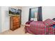 Cozy bedroom featuring a plaid comforter, a dresser, and a window with curtains at 19823 E 58Th Ave, Aurora, CO 80019