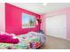 Vibrant pink bedroom with a twin bed, floral bedding, and a window showcasing a view at 19823 E 58Th Ave, Aurora, CO 80019