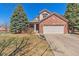 Charming brick two-story home with mature trees and attached two-car garage at 19823 E 58Th Ave, Aurora, CO 80019