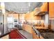 Modern kitchen with wood cabinetry, stainless appliances, concrete ceiling, and a granite topped island at 1610 Little Raven St # 502, Denver, CO 80202