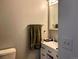 Bathroom featuring a towel rack, mirror, sink with a white vanity, and a toilet at 3190 S Joplin Ct, Aurora, CO 80013