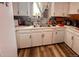 Bright kitchen featuring white cabinets, stainless steel sink and wood style flooring at 3190 S Joplin Ct, Aurora, CO 80013