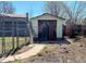 An outdoor shed with wood doors sits in the backyard behind a chain link fence, offering storage at 3190 S Joplin Ct, Aurora, CO 80013