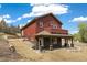 A view of a house exterior including the yard, porch, and surrounding landscape at 826 Meadow Ln, Palmer Lake, CO 80133