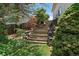 Backyard features stone-framed stairs with vibrant landscaping and mature trees, adding natural charm at 11149 Seton Pl, Westminster, CO 80031