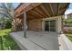 View of the covered backyard patio beneath the deck, with brick accents and sliding glass door at 11149 Seton Pl, Westminster, CO 80031