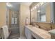 En suite bathroom with a tiled vanity, medicine cabinet, and a door leading to a tiled shower area at 11149 Seton Pl, Westminster, CO 80031