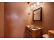 Rustic half-bathroom with bronze walls, and a custom sink set inside a beautiful wooden vanity at 11149 Seton Pl, Westminster, CO 80031