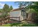 Backyard storage shed, featuring neutral siding, a brown roof, and surrounding fence and mature landscaping at 11149 Seton Pl, Westminster, CO 80031