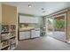 Convenient wet bar area featuring white cabinets, modern shelving, and sliding glass doors to the patio at 11149 Seton Pl, Westminster, CO 80031