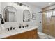 Modern bathroom featuring a double vanity, updated shower, and stylish mirrors at 2800 N Harrison St, Denver, CO 80205