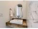 Modern half-bath features a unique mirror, white tiles, and wooden vanity at 8982 Spaulding St, Parker, CO 80134