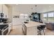 Open kitchen featuring quartz counters, an island with seating, and modern appliances at 8982 Spaulding St, Parker, CO 80134