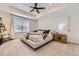Bright main bedroom featuring a ceiling fan, tray ceiling, and large window for natural light at 8982 Spaulding St, Parker, CO 80134