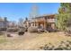 Spacious backyard with a stone patio, deck, and lush landscaping, perfect for outdoor activities at 6406 Eagle Ct, Longmont, CO 80503