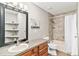 Bathroom featuring a granite vanity, built in mirror shelving, and tiled shower/tub combo at 6406 Eagle Ct, Longmont, CO 80503