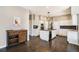 Spacious kitchen featuring white cabinets, an island with a cooktop, and modern appliances at 6406 Eagle Ct, Longmont, CO 80503