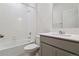 Bright bathroom with white tiling around tub and shower with gray cabinet sink at 6500 13Th St, Frederick, CO 80530