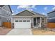 Charming single-story home with gray siding, stone accents, and a two-car garage at 6500 13Th St, Frederick, CO 80530