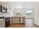 Modern kitchen with stainless steel appliances and island counter overlooking the living space at 6500 13Th St, Frederick, CO 80530