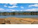 Scenic lake view featuring beautiful water, community homes, mountains, and a bright blue sky with fluffy white clouds at 6500 13Th St, Frederick, CO 80530
