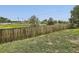 Fenced backyard featuring well-maintained grass and mature trees providing a private and serene outdoor space at 11062 Hudson Ct, Thornton, CO 80233