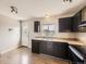 Well-lit kitchen with dark cabinets, stainless steel appliances, and wood-look flooring at 11062 Hudson Ct, Thornton, CO 80233