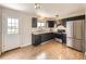 Well-lit kitchen with dark cabinets, stainless steel appliances, and wood-look flooring at 11062 Hudson Ct, Thornton, CO 80233