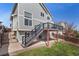 A two-story home featuring a deck and a backyard with green grass, patio, and stairs to the upper deck at 8414 Bed Straw St, Parker, CO 80134