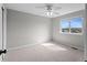 Bright bedroom features neutral carpet, a ceiling fan, and window with views at 8414 Bed Straw St, Parker, CO 80134