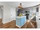 Well-lit kitchen featuring stainless appliances, gray cabinets, blue backsplash, and hardwood floors at 8414 Bed Straw St, Parker, CO 80134