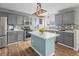 Modern kitchen showcasing stainless steel appliances, gray cabinets, a center island, and wood flooring at 8414 Bed Straw St, Parker, CO 80134