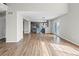 Open concept living area featuring wood flooring, light gray walls, and a modern kitchen in the background at 8414 Bed Straw St, Parker, CO 80134